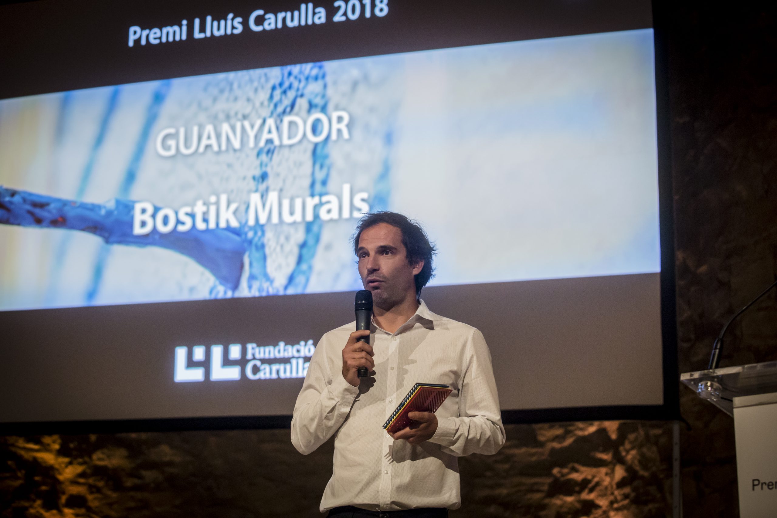 Xavier Ballaz de B-Murals parlant a l'escenari durant el lliurament del Premi Lluís Carulla 2018.